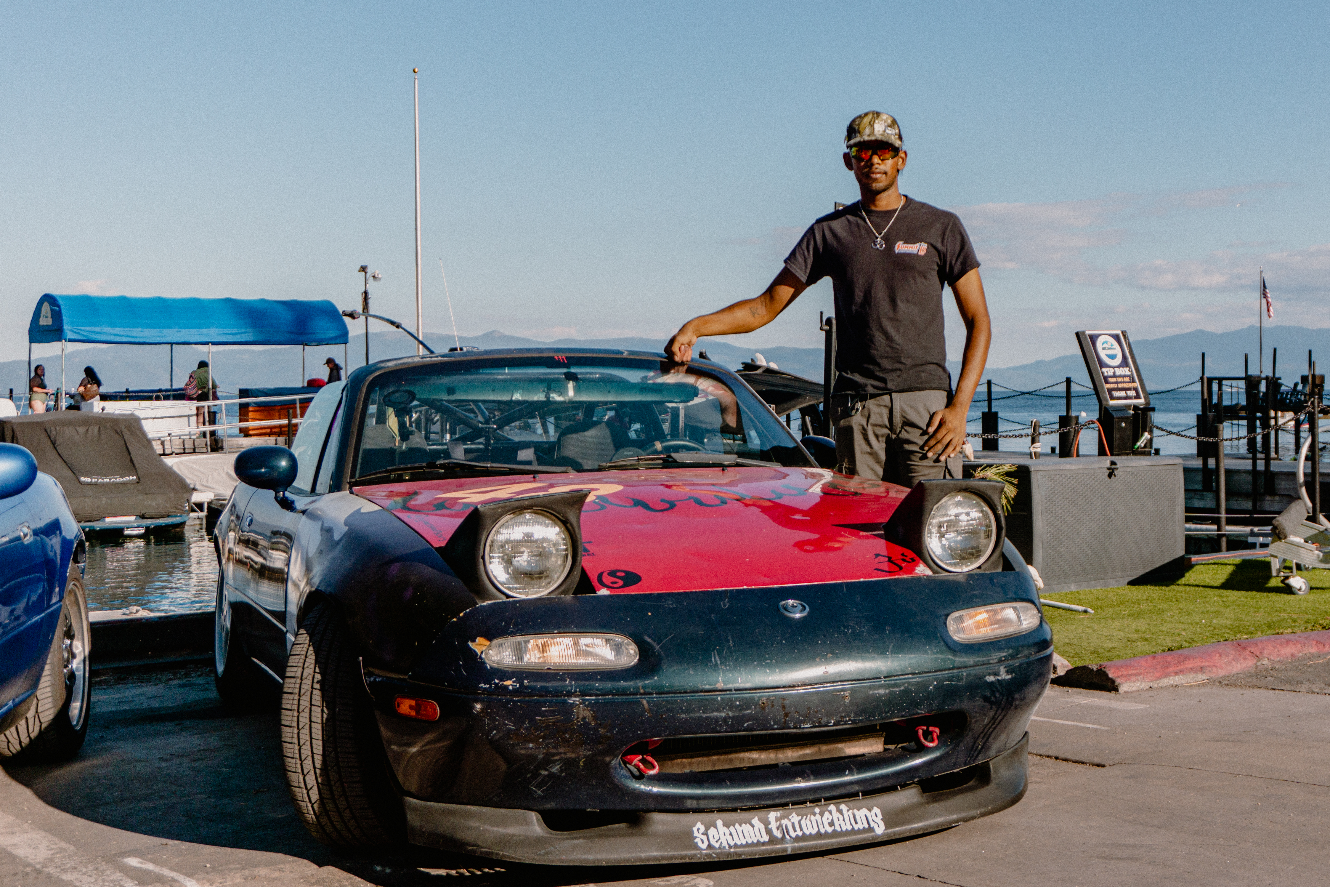 Noisyboy standing beside his drift car by the waterfront